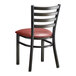 A black metal Lancaster Table & Seating ladder back chair with a burgundy vinyl padded seat.