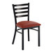 A metal ladder back chair with a distressed copper finish and a burgundy vinyl padded seat.