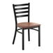 A black metal ladder back chair with an antique walnut wood seat.