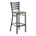 A black metal ladder back bar stool with a detached driftwood-colored seat.