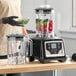 A commercial blender with touchpad controls, timer, adjustable speed, and two 48 oz. Tritan containers.