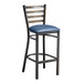 A Lancaster Table & Seating metal bar stool with a navy blue cushion.