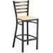 A Lancaster Table & Seating black metal bar stool with a natural wood seat.