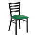 A black ladder back chair with a green vinyl padded seat and a distressed copper finish.