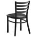 A Lancaster Table & Seating black metal ladder back chair with black vinyl padded seat.