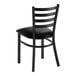 A black metal ladder back chair with a black vinyl padded seat.