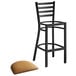 A Lancaster Table & Seating black ladder back bar stool with light brown vinyl padded seat.