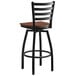 A Lancaster Table & Seating black ladder back bar stool with a wooden seat.