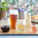 A tray of Choice clear plastic stemless wine glasses filled with red and white wine on a table.