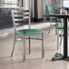 A Lancaster Table & Seating green vinyl padded chair seat on a ladder back chair.