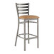 A Lancaster Table & Seating metal bar stool with a light brown vinyl padded seat.