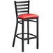 A Lancaster Table & Seating black ladder back bar stool with a red padded seat.