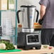 A large stainless steel commercial food blender with variable speed controls.