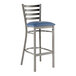 A Lancaster Table & Seating metal bar stool with a navy blue vinyl padded seat.