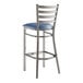 A Lancaster Table & Seating metal ladder back bar stool with navy blue vinyl padded seat.