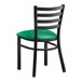 A Lancaster Table & Seating black metal ladder back chair with green vinyl padded seat.