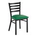 A black ladder back chair with a green vinyl padded seat.