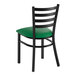 A black ladder back chair with a green vinyl padded seat.