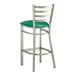 A Lancaster Table & Seating metal ladder back bar stool with green vinyl padded seat.