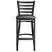 A Lancaster Table & Seating black ladder back bar stool with a black padded seat.