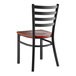A Lancaster Table & Seating black finish ladder back chair with a mahogany wood seat.