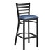 A Lancaster Table & Seating black ladder back bar stool with a navy blue vinyl padded seat.