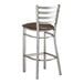 A Lancaster Table & Seating metal bar stool with a dark brown vinyl padded seat.