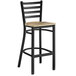 A Lancaster Table & Seating black ladder back bar stool with a driftwood seat.