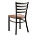 A Lancaster Table & Seating black metal ladder back chair with a brown wood seat.