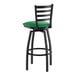 A black metal swivel bar stool with a ladder back and a green vinyl padded seat.