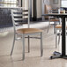 A Lancaster Table & Seating ladder back chair with a light brown vinyl padded seat.