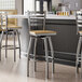 A group of Lancaster Table & Seating Ladder Back Swivel Bar Stools with driftwood seats at a kitchen counter.