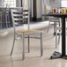 A Lancaster Table & Seating clear coat finish ladder back chair with a driftwood seat at a table with drinks.