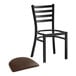 A Lancaster Table & Seating black ladder back chair with a dark brown vinyl padded seat.