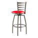 A red and silver Lancaster Table & Seating swivel bar stool with a red vinyl padded seat.