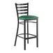A black metal bar stool with a ladder back design and a green vinyl padded seat.