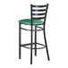 A black metal bar stool with a ladder back design and a green vinyl padded seat.