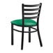 A Lancaster Table & Seating black metal ladder back chair with a green vinyl padded seat.