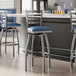 Lancaster Table & Seating clear coat finish ladder back swivel bar stools with navy vinyl padded seats.
