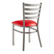 A Lancaster Table & Seating metal ladder back chair with red vinyl seat pad.