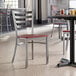 A Lancaster Table & Seating ladder back chair with a mahogany seat at a table in a restaurant.