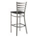 A Lancaster Table & Seating metal ladder back bar stool with a black wood seat.