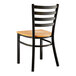 A Lancaster Table & Seating distressed copper finish ladder back chair with a natural wood seat on a black metal frame.