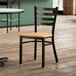 A Lancaster Table & Seating wooden chair with a natural wood seat at a table in a restaurant.