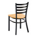 A ladder back chair with a black metal frame and a natural wood seat.