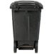 A black Toter trash can with wheels.