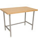 An Advance Tabco wood top work table with a stainless steel base.