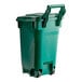 A green plastic Toter trash can with wheels and a lid.