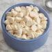 A close-up of a bowl filled with Guittard White .9M Baking Chips.