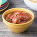 A table with bowls of salsa and chips including a tropical yellow Diamond Mardi Gras melamine bowl.